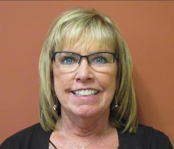 Female SERVPRO employee with blonde hair, green eyes, and glasses smiling