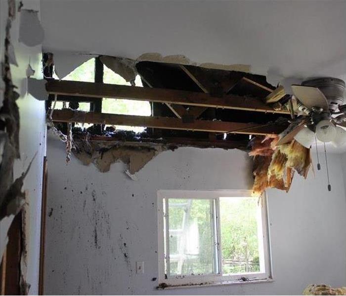 Hole in the ceiling of a bedroom after fire damage.