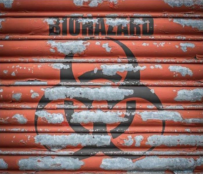 Biohazard sign on red garage door.
